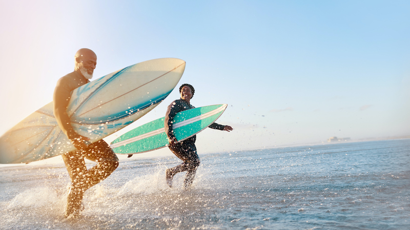 older couple surfing with a sun glow